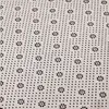 A close-up view of the textured underside of a rug, showing a pattern of small dots and floral shapes. Náhled obrázku produktu