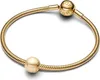 A gold Pandora bracelet with a charm and a clasp charm. Podgląd zdjęcia produktu