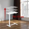 A white adjustable standing desk is shown in a room with wooden flooring and a window with brown curtains. Voir les images du produit