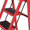 A close-up view of a red step stool with black anti-slip treads. Produktbild-Vorschau