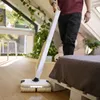 A person is using a floor cleaner in a bedroom with a bed and a large teddy bear. Anteprima dell’immagine prodotto