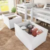 Two white storage drawers filled with stuffed animals and blankets are placed on a brown rug in front of a white bunk bed. Voir les images du produit