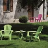 A garden scene with colorful plastic chairs and a table set up on a lawn in front of a building. Produktbild-Vorschau