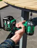 A person is using a HiKOKI cordless impact driver to attach a screw to a wooden table outdoors. Voir les images du produit