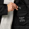 A person's hand is shown reaching into the inside pocket of a black jacket. Produktbild-Vorschau