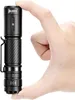 A hand is holding a small black flashlight. Produktbild-Vorschau