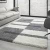 A modern living room with a sofa and a geometric rug.