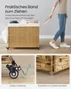 A person is pulling a wicker laundry basket with a strap. The image is split into three sections, showing the full product, a close-up of the wheels, and a close-up of the feet. Produktbild-Vorschau