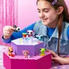 A young girl is playing with a set of small animal toys on a multi-tiered display stand. Náhled obrázku produktu
