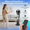 A woman is using a remote control to operate a standing fan with a humidifier in a living room setting. Voir les images du produit