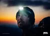 A man wearing a headlamp looks up at the sky during sunset. Náhľad obrázku produktu
