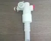 A white plastic filling valve for a toilet cistern is placed on a wooden surface. Produktbild-Vorschau