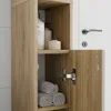 A close-up view of a narrow wooden bathroom cabinet with shelves and an open door, showing toiletries and rolled towels. Náhled obrázku produktu
