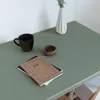 A desk with a cup, a small bowl of paperclips, and two notebooks. Produktbild-Vorschau
