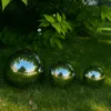 Three polished stainless steel garden spheres of varying sizes are placed on a grassy lawn, reflecting the surrounding trees and architecture. Produktbild-Vorschau