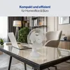 A white table fan is placed on a desk next to a laptop in a home office setting. Podgląd zdjęcia produktu