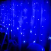 A close-up view of blue snowflake-shaped string lights hanging against a blue curtain. Náhled obrázku produktu