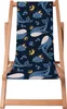 A wooden deck chair with a dark blue fabric seat featuring a pattern of whales, moons, and stars. Náhled obrázku produktu