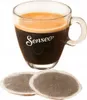 A cup of coffee with Senseo branding and two coffee pods. Náhľad obrázku produktu
