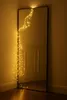 Fairy lights draped over a mirror in a corner of a room. Produktbild-Vorschau