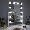 A vanity mirror with lights is displayed on a desk with makeup and a magazine. Podgląd zdjęcia produktu