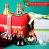 Christmas ornaments filled with candies and liquid, placed on gift boxes. Produktbild-Vorschau