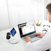A person is working on a laptop at a desk with a wireless charging station for multiple devices. Produktbild-Vorschau