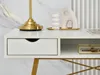 A close-up view of a white desk with gold accents, showing a drawer, an open shelf with a decorative box, and a gold lamp. Voir les images du produit