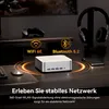 A mini PC is shown on a desk with a mouse, keyboard, headphones, and a game controller in the background. There are also icons indicating WiFi and Bluetooth connectivity. Produktbild-Vorschau