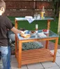A person is preparing food on a wooden table outdoors. Anteprima dell’immagine prodotto