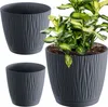 Three dark gray planters with a wavy texture, one of which contains a green plant. Produktbild-Vorschau