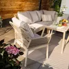 An outdoor furniture set on a patio with wooden wall background and plants. Náhľad obrázku produktu
