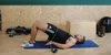 A man is doing a glute bridge exercise with a resistance band around his thighs in a gym. Náhled obrázku produktu