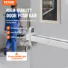 A person in scrubs walks past a high-quality door push bar installed on a door in what appears to be a hospital or medical facility. Podgląd zdjęcia produktu
