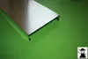 A metal sheet with bent edges is placed on a green surface. Produktbild-Vorschau