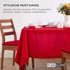 A table set for a meal with a red tablecloth, chairs, and place settings. Anteprima dell’immagine prodotto
