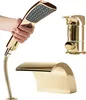 A hand holding a gold shower head, with a gold faucet and a gold bathtub spout in the background. Produktbild-Vorschau