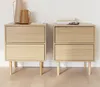Two wooden nightstands with two drawers each, placed against a white wall on a wooden floor. Anteprima dell’immagine prodotto