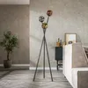A modern living room with a tripod floor lamp with three globe-shaped lights, a potted plant, and a sofa. Produktbild-Vorschau