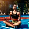 A woman is sitting on a blue and red court, wearing headphones and holding a phone, appearing to be meditating or listening to music. Náhľad obrázku produktu