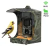 A bird feeder with a built-in camera, featuring a solar panel and Wi-Fi connectivity, with a goldfinch perched on it. Podgląd zdjęcia produktu