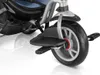 A close-up view of the front wheel and footrest of a tricycle. Produktbild-Vorschau