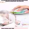 A woman is using a laptop while a baby sleeps nearby. A hand is shown holding a wireless mouse with LED lights. Produktbild-Vorschau
