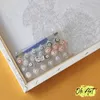 A paint-by-numbers kit is laid out on a canvas, with small pots of paint and brushes visible. Produktbild-Vorschau