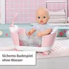 A baby doll sitting in a pink toy bathtub with a shower head. Produktbild-Vorschau