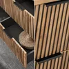 A split image showing a close-up of a wooden cabinet with ribbed detailing and black handles, and a drawer pulled out revealing a woven basket. Produktbild-Vorschau