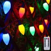 A string of colorful LED lights is draped over a wooden fence. Produktbild-Vorschau