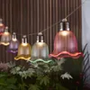 A string of decorative lights shaped like tulips, hanging in a garden setting. Produktbild-Vorschau