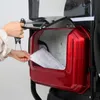 A person is placing a document into a red storage compartment on a three-wheeled vehicle. Produktbild-Vorschau