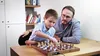 A man and a boy are playing chess at a table. Podgląd zdjęcia produktu